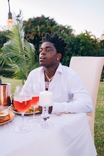 man in white dress shirt sitting on white chair