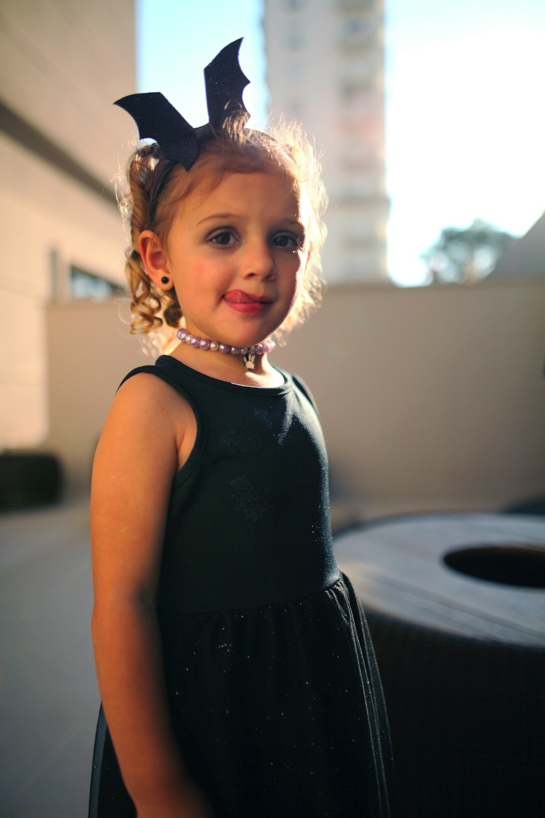 girl in black sleeveless dress standing near window during daytime