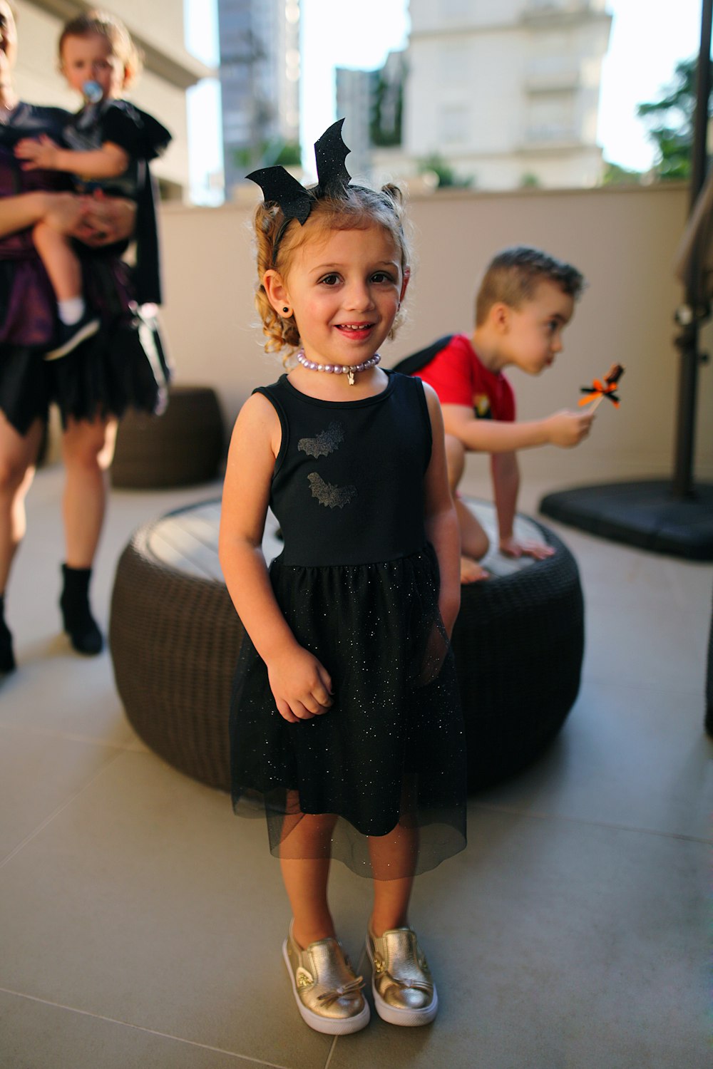 girl in black dress standing on white floor tiles