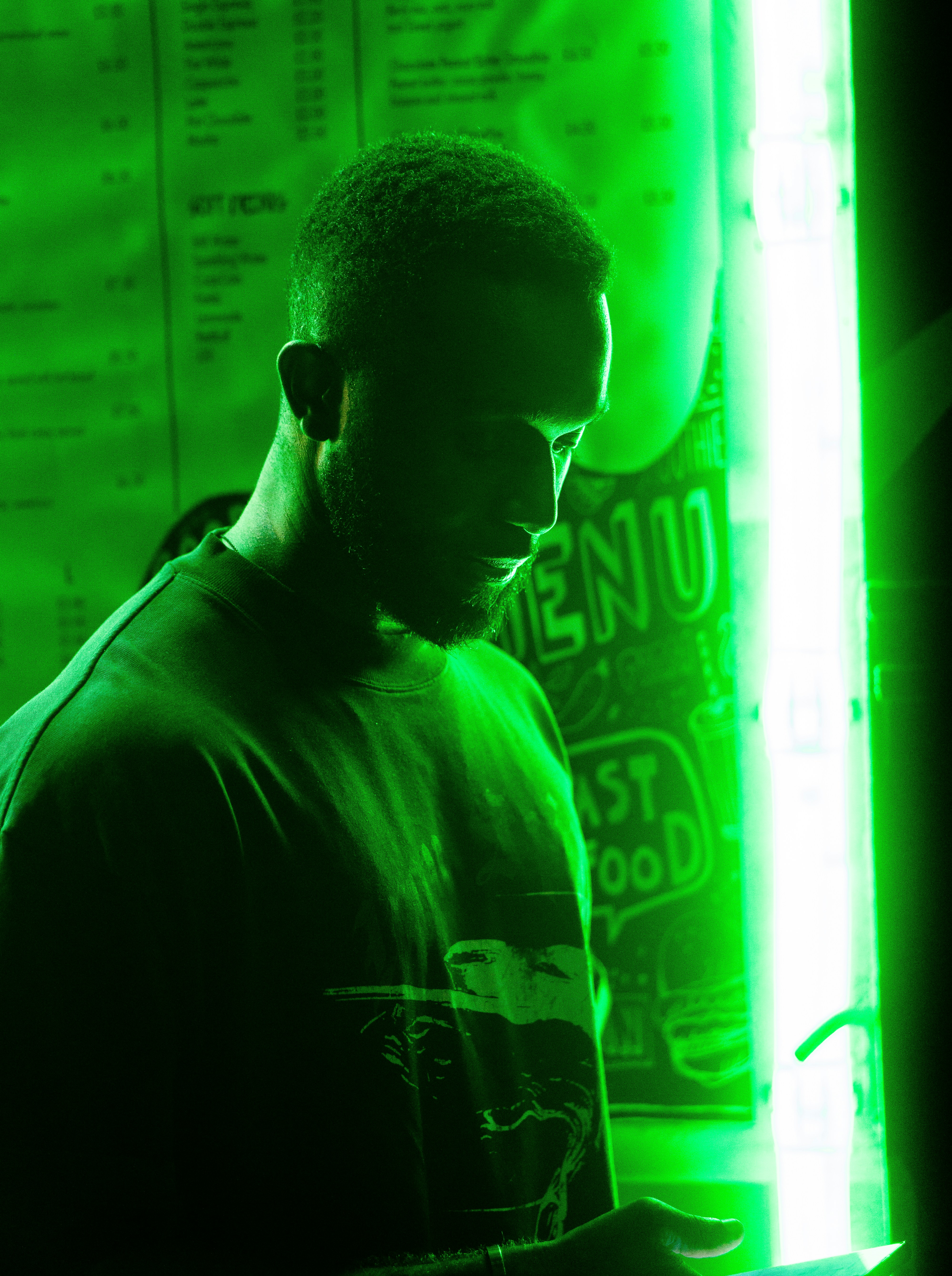 man in black crew neck shirt standing near neon lights