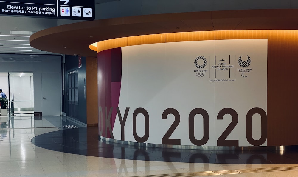 a man standing in front of a large sign in an airport