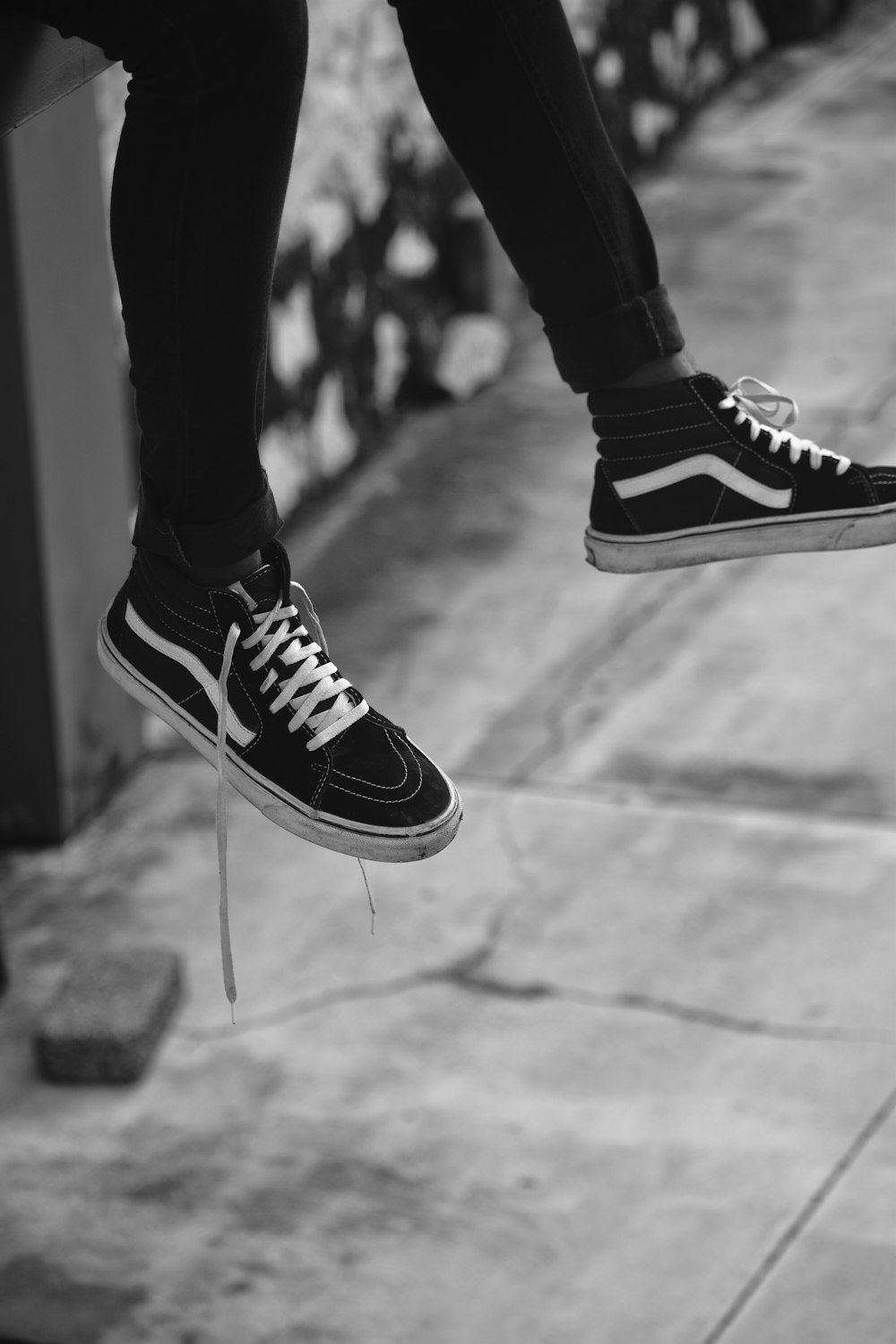 person wearing black and white vans low top sneakers