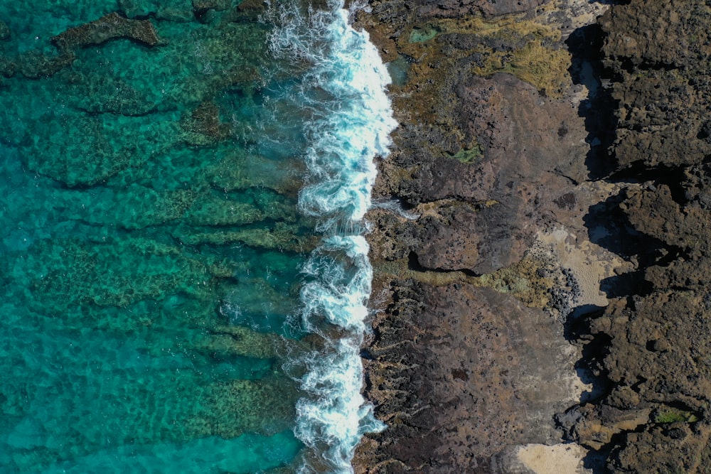 brown rocky shore with water waves during daytime