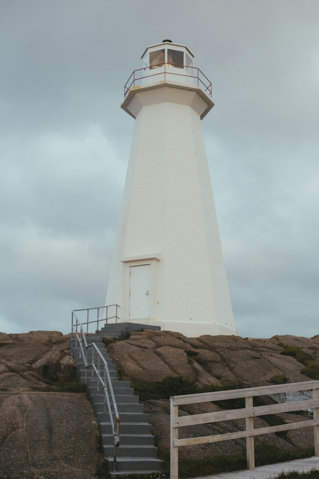 white lighthouse under cloudy sky during daytime