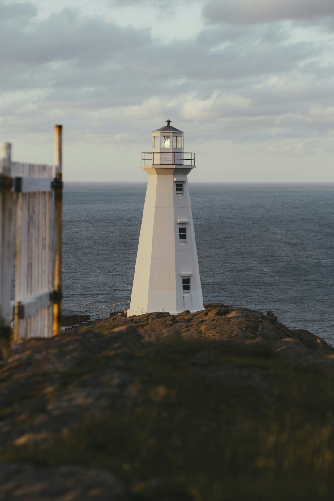 white lighthouse near body of water during daytime