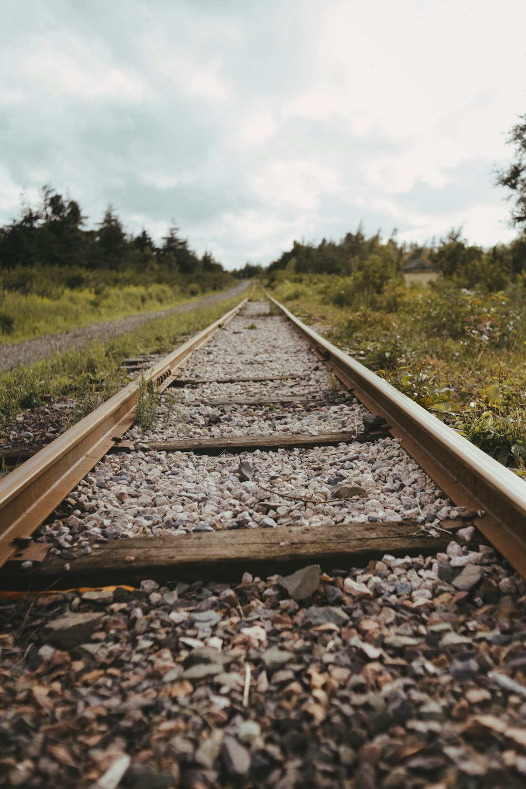 brown wooden train rail near green grass field during daytime