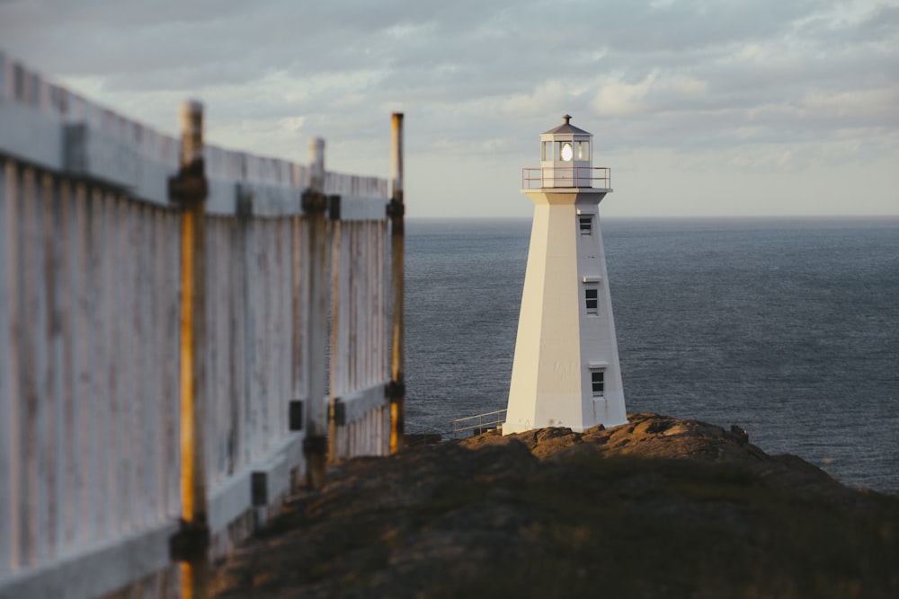 white lighthouse near body of water during daytime