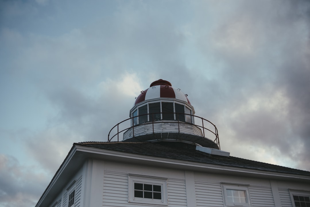 white and red concrete building under white clouds during daytime