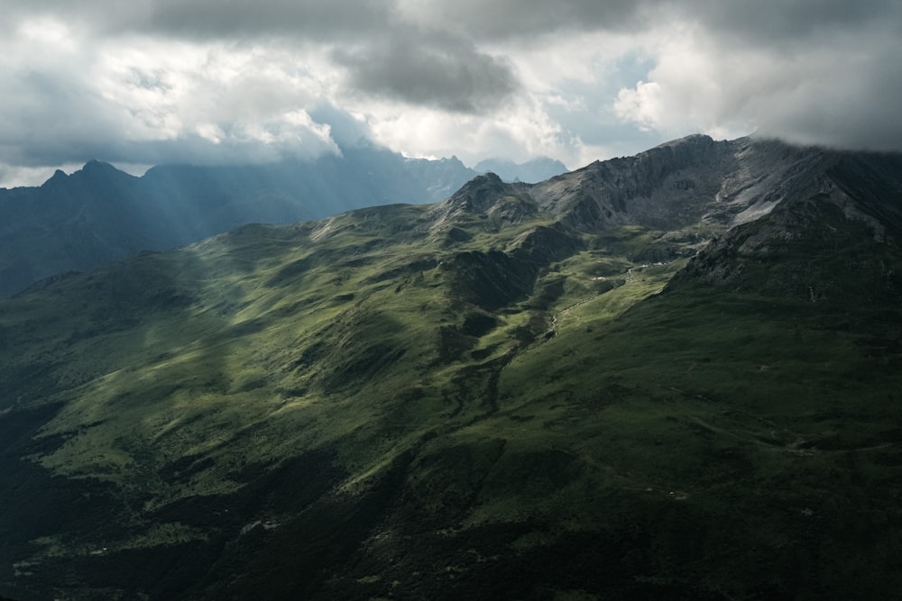 green and brown mountains under white clouds and blue sky during daytime