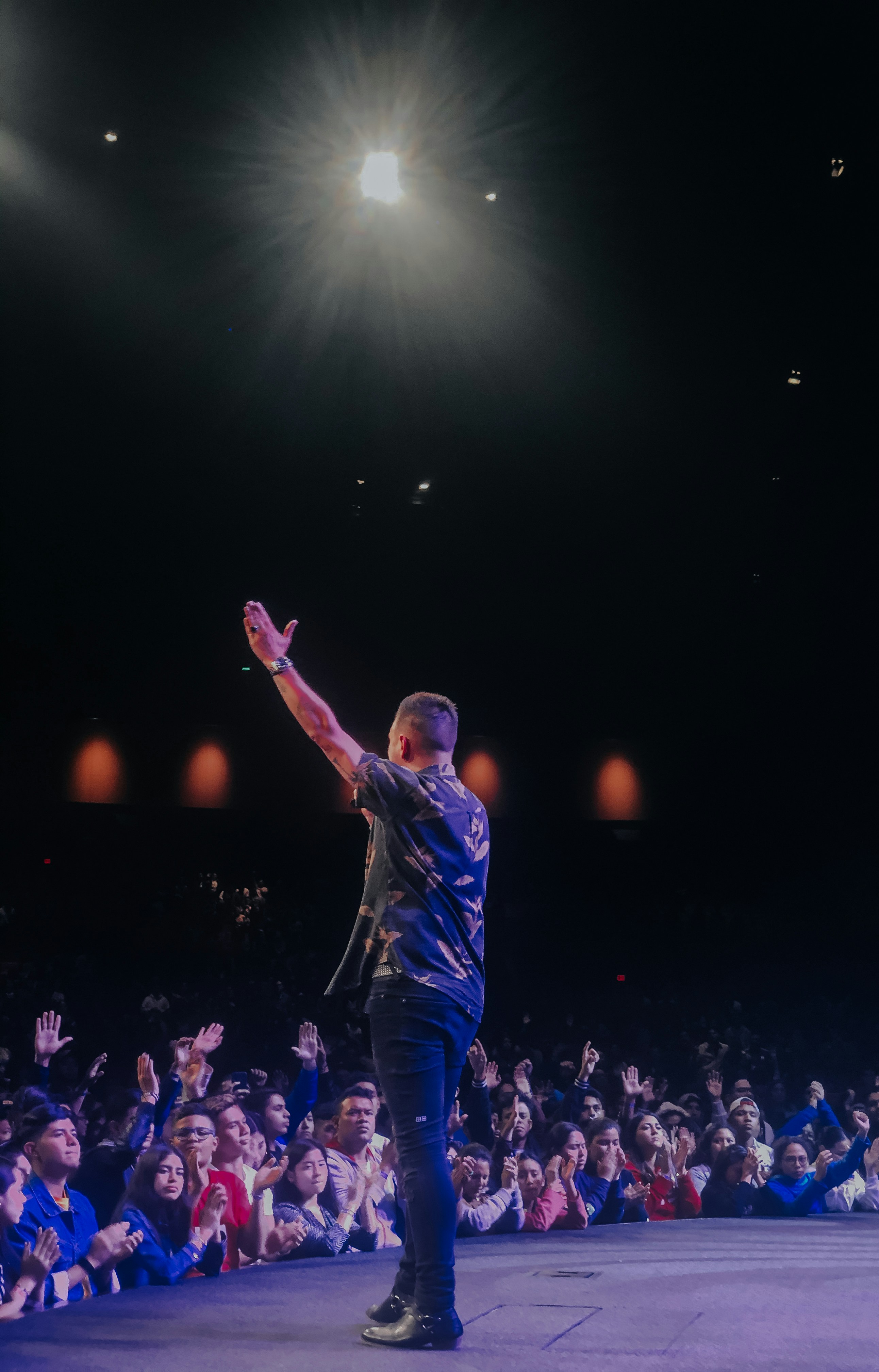 man in blue shirt standing on stage