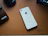 A bright, colorful iPhone 15 Pro Max case resting on a wooden table beside keys.