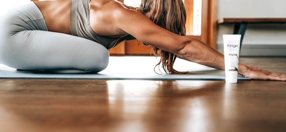 woman in gray sports bra and gray leggings lying on floor