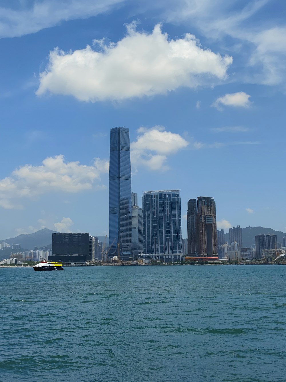 white boat on sea near city buildings during daytime