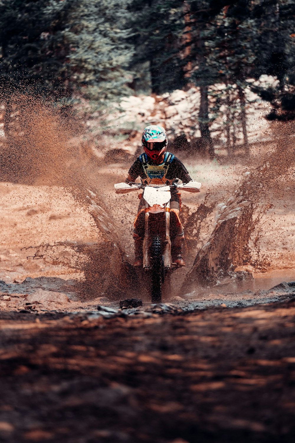 man in red helmet riding motocross dirt bike on dirt road during daytime