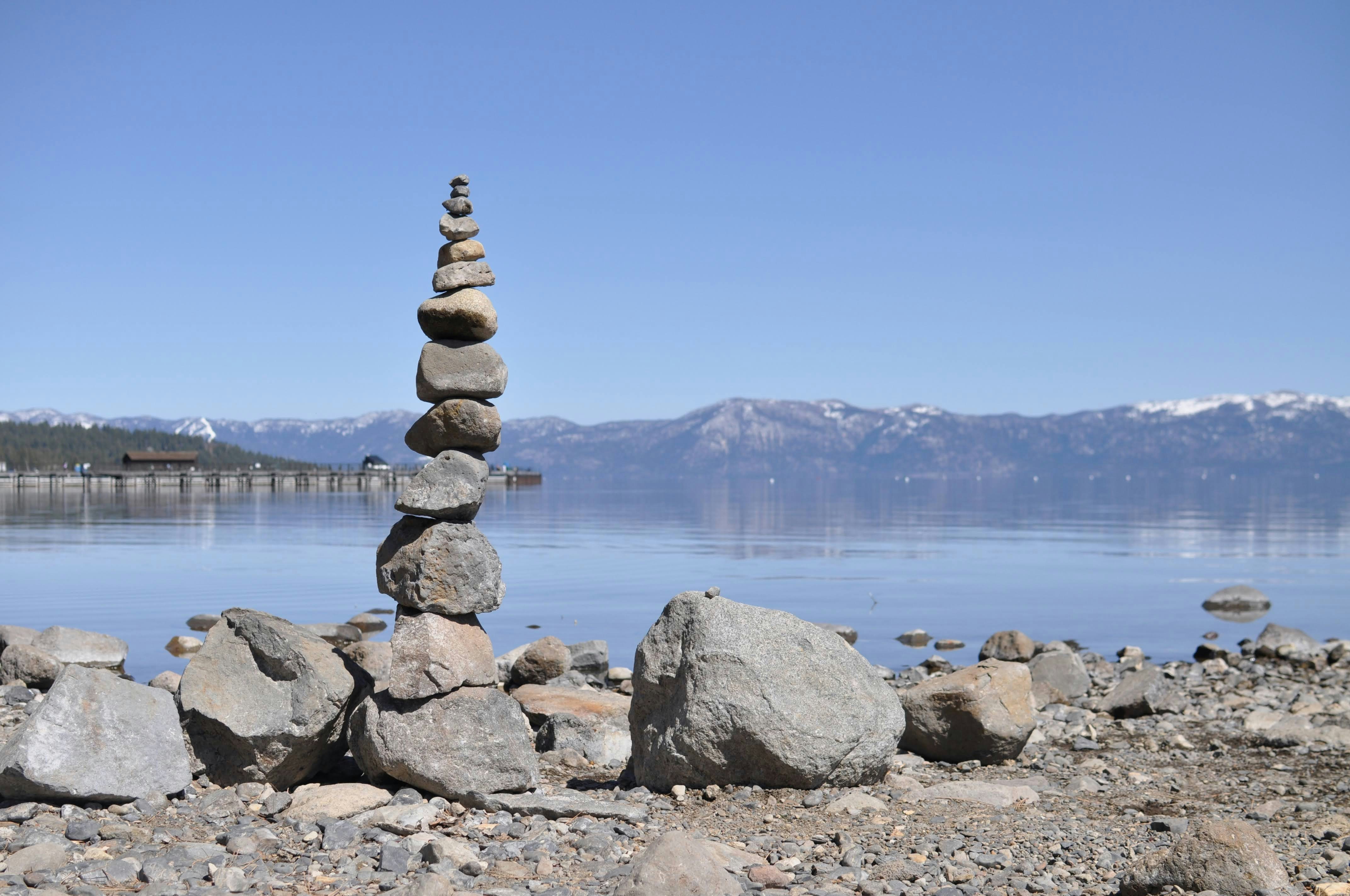 Piedra marrón y gris cerca del cuerpo de agua durante el día