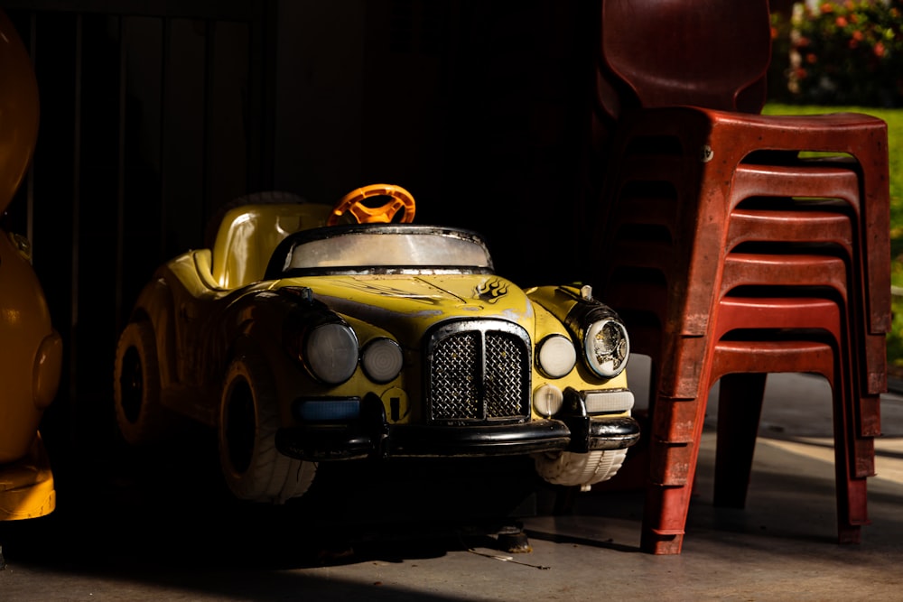 yellow and black porsche 911 parked in front of red building