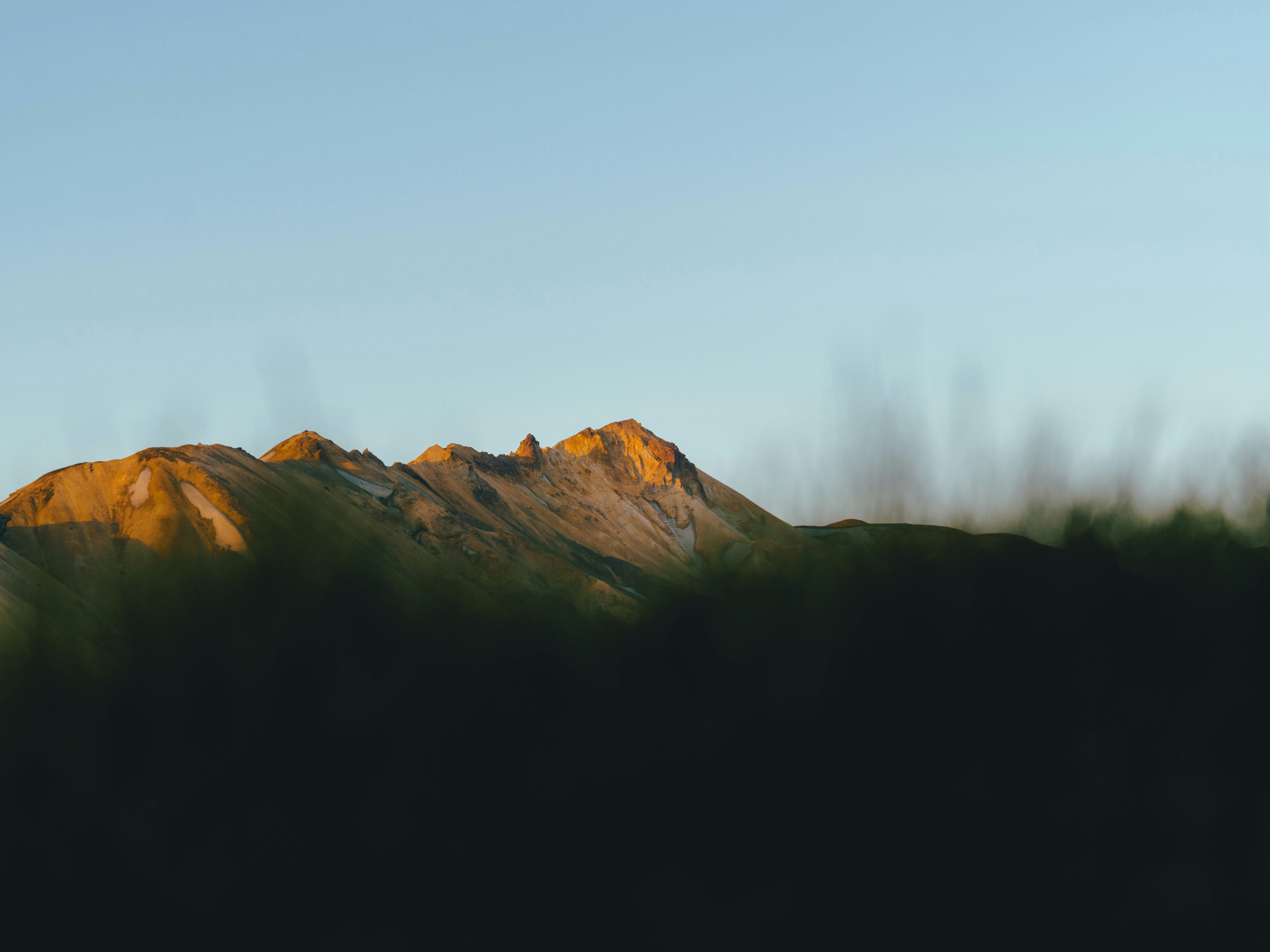 昼間の青空に覆われた茶色の岩山