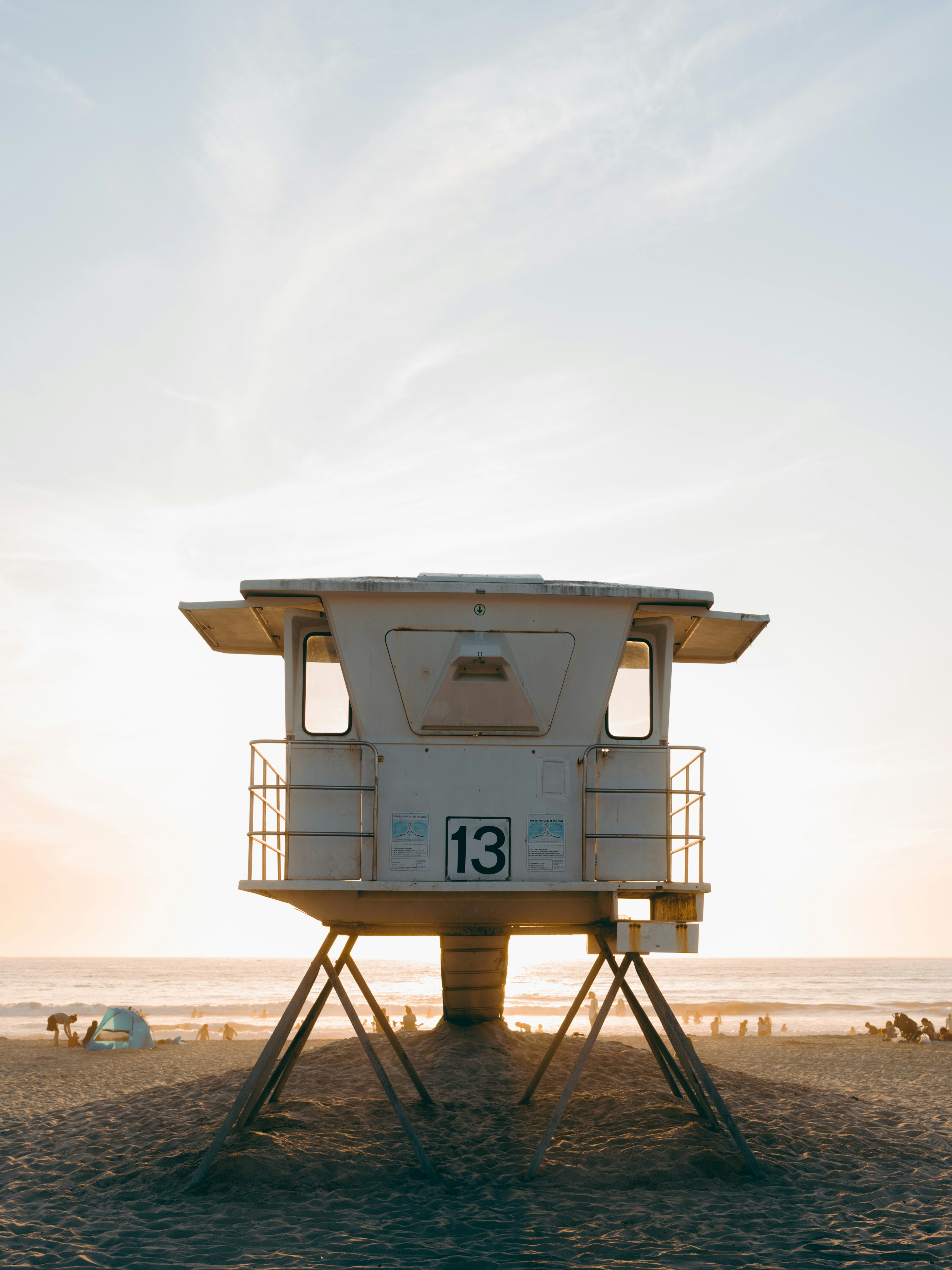 日中のビーチにある白いライフガードハウス