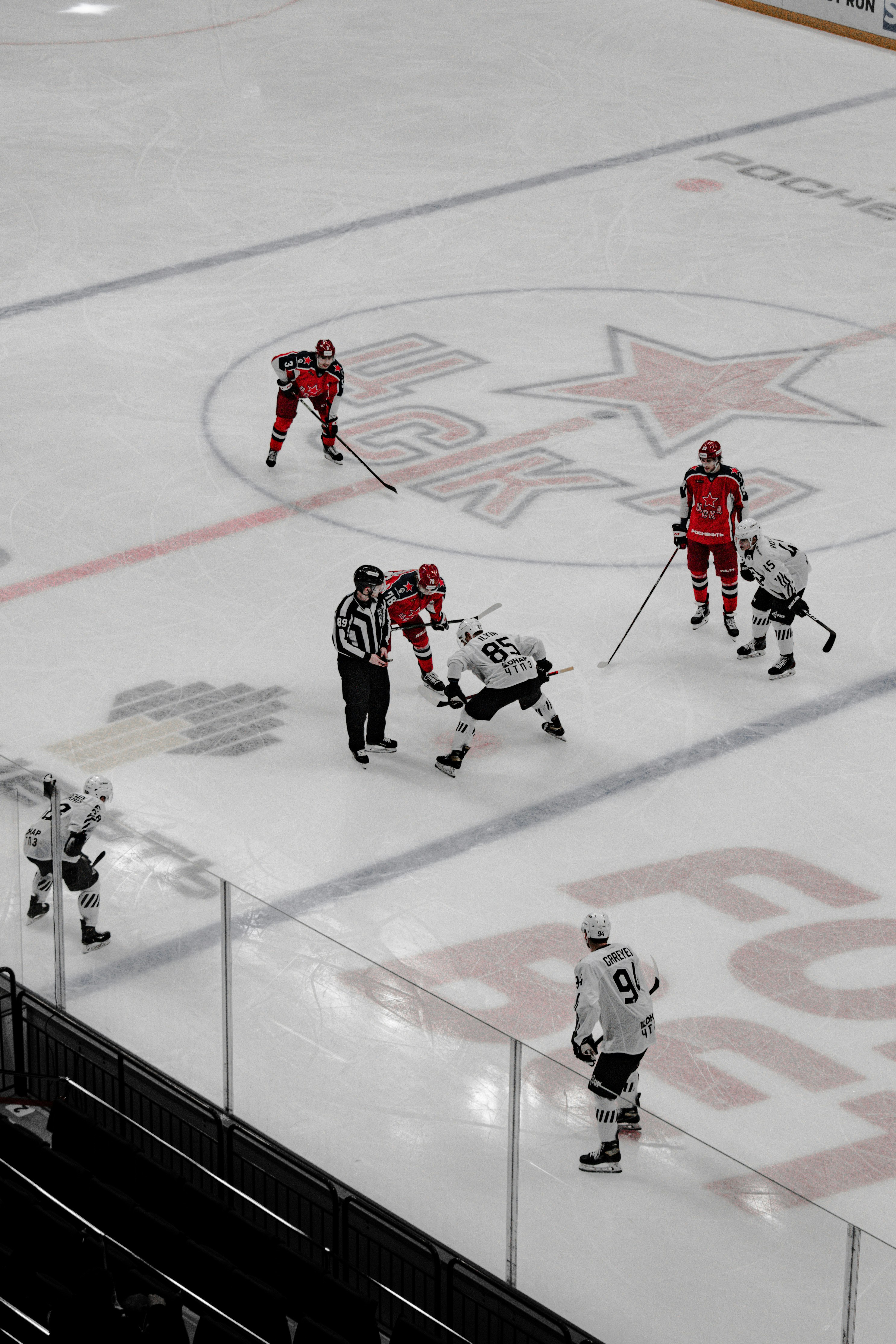 2 men playing hockey on ice field