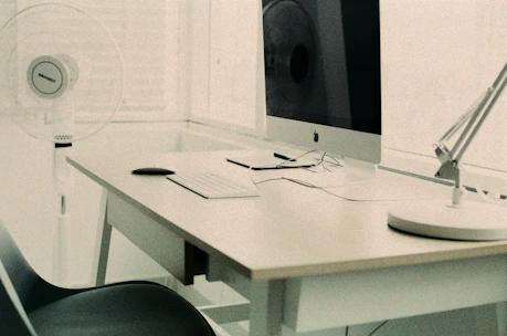 Minimalist workspace with sleek Apple-style devices and clean white background.