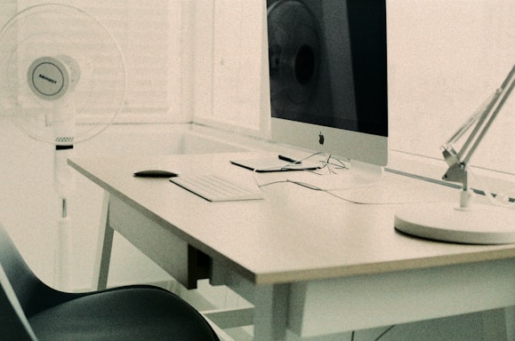 Modern minimalist workspace with Apple devices and a sleek white desk.