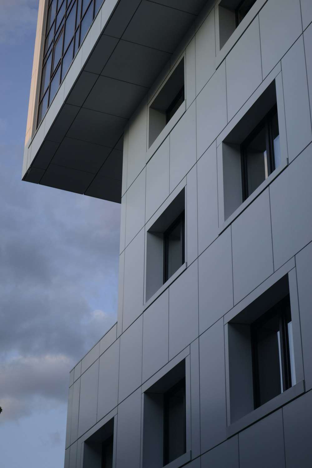 white concrete building under white clouds during daytime