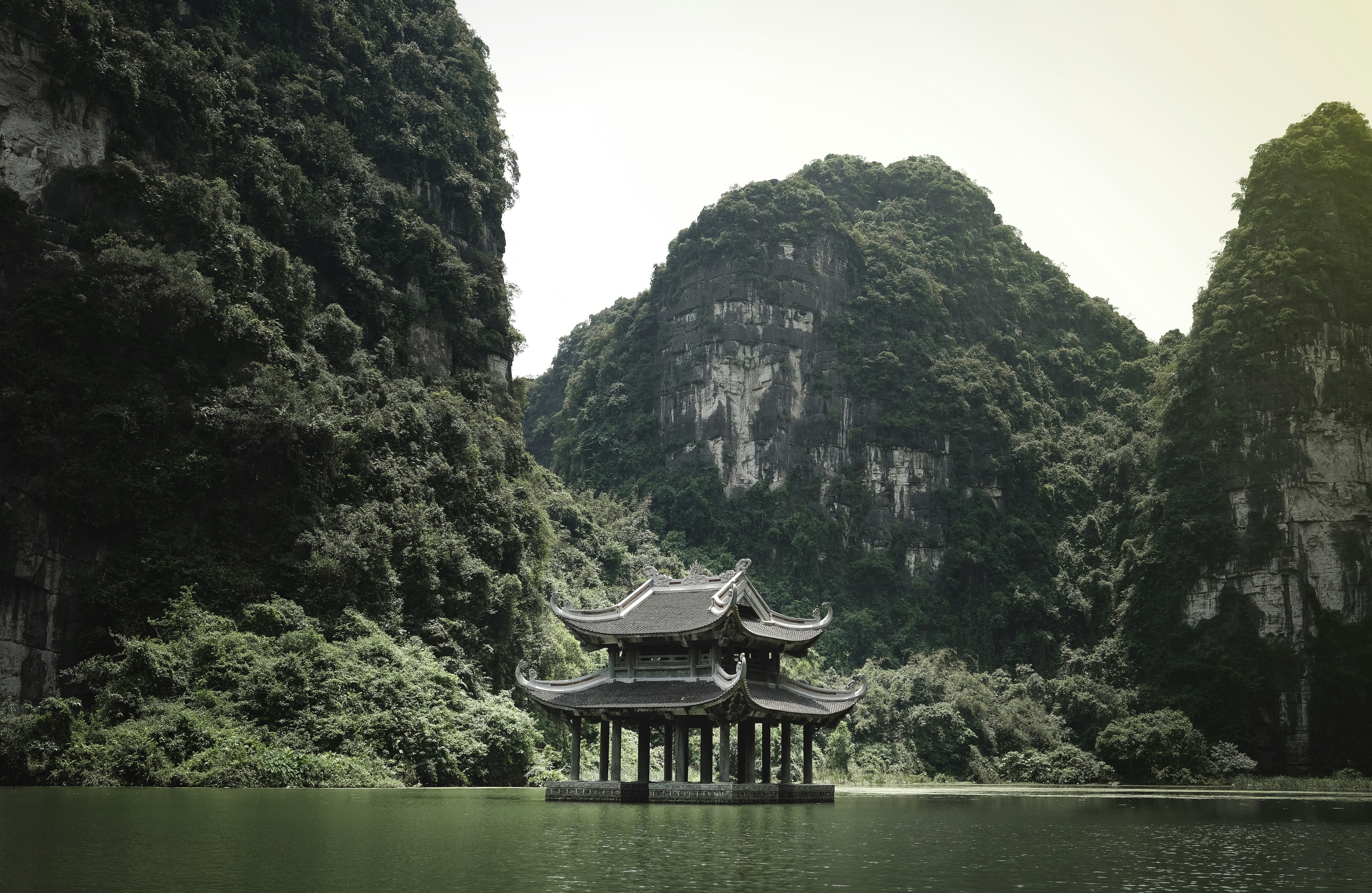 brown wooden house on lake near mountain during daytime