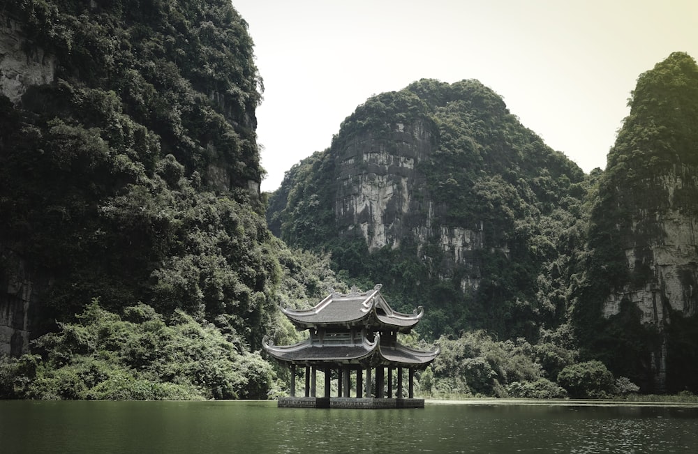 brown wooden house on lake near mountain during daytime