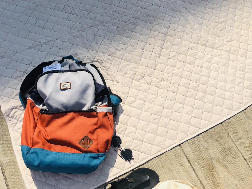 black and orange backpack on white floor