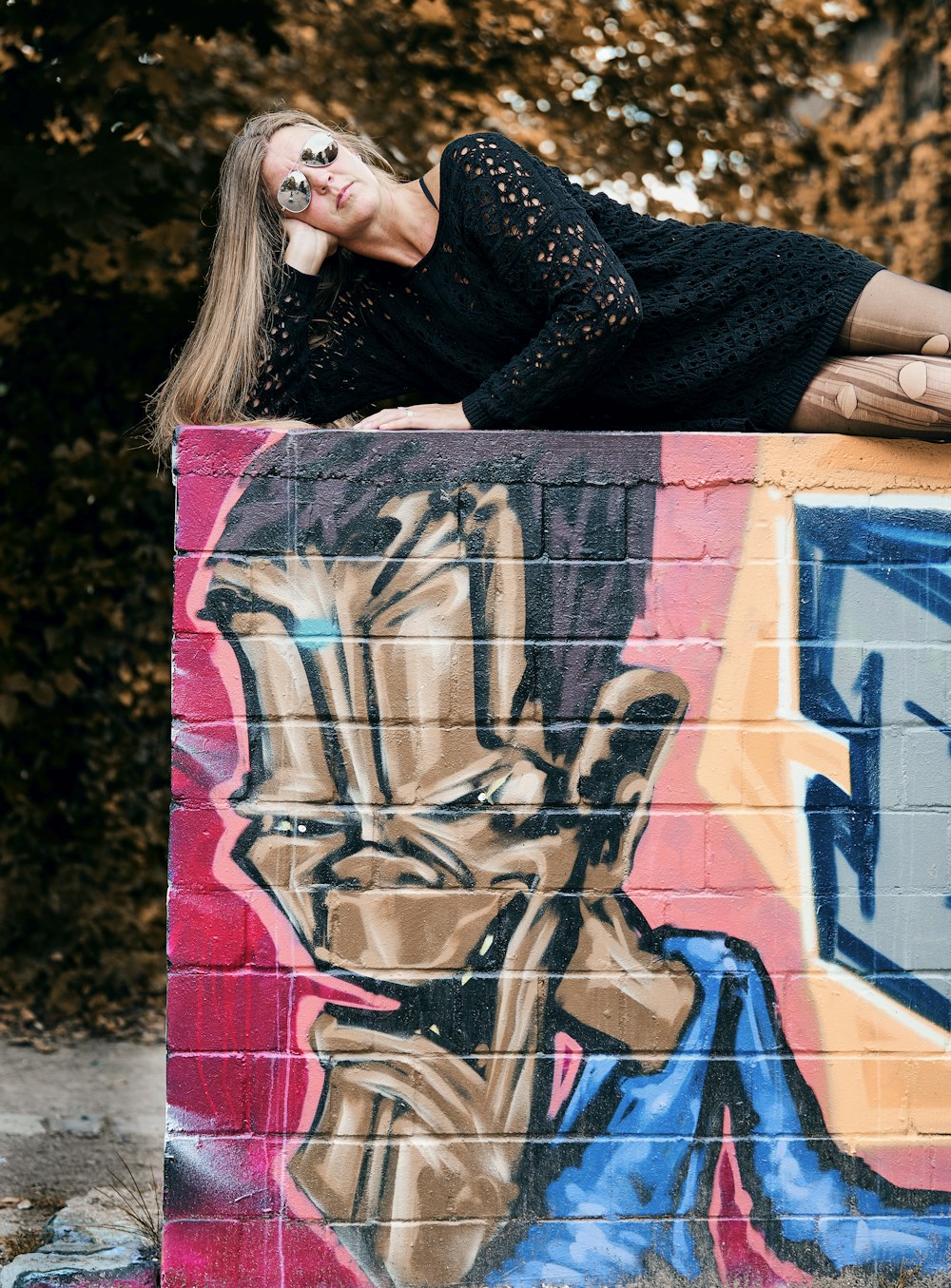 woman in black dress holding white blue and red abstract painting