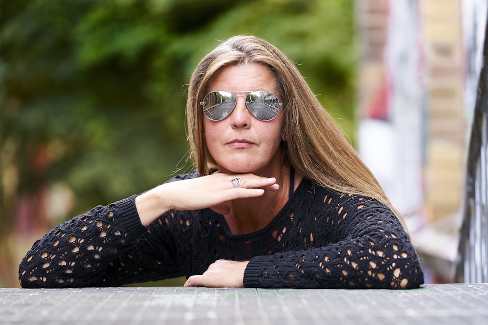 Mujer con camisa de manga larga de lunares en blanco y negro con gafas de sol marrones