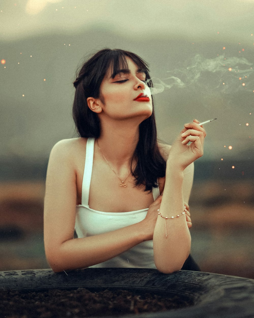 woman in white tank top smoking cigarette