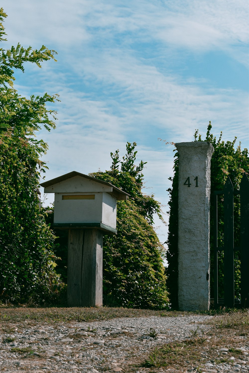 weißes und grünes Holzhaus in der Nähe grüner Bäume unter blauem Himmel tagsüber