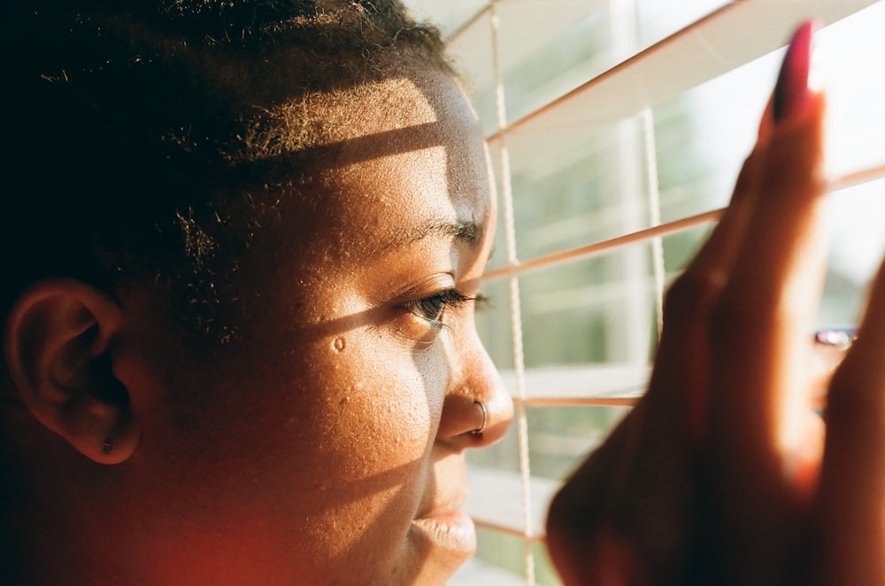 woman in red shirt near window