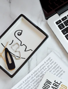 Elegant flat lay of a beauty professional's workspace with a laptop showing a payment policy page.