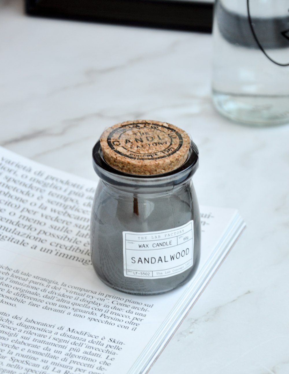 clear glass jar with brown lid on white printer paper