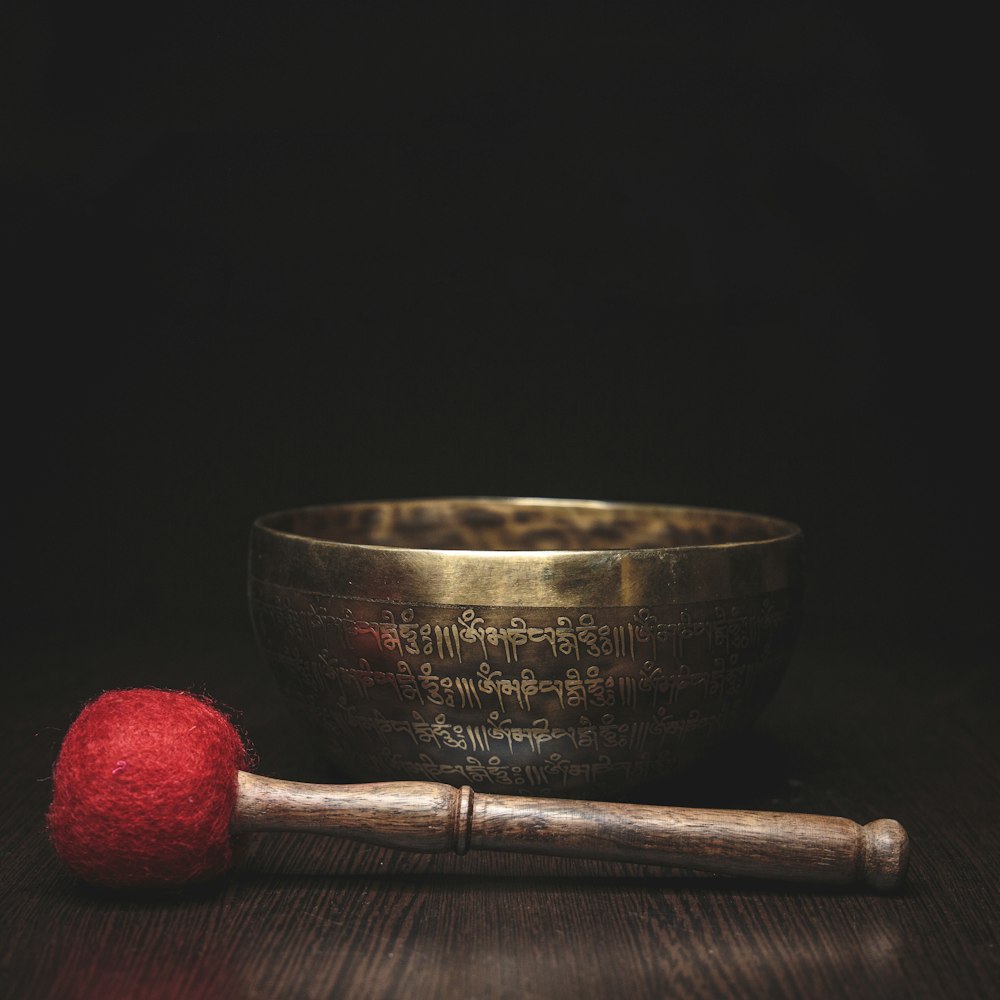 red and brown wooden rolling pin beside brown round bowl