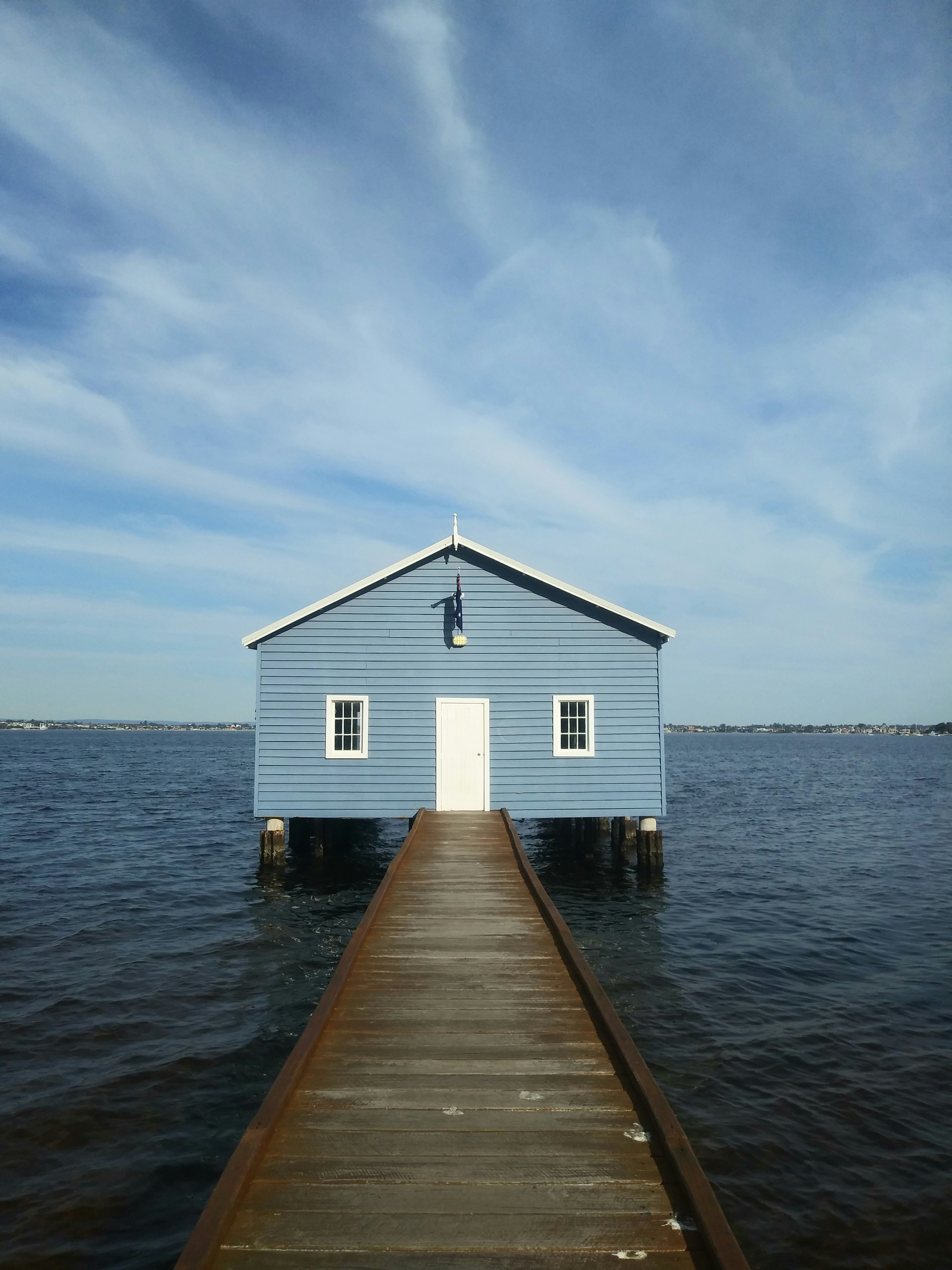 white and blue wooden house on sea under blue sky during daytime