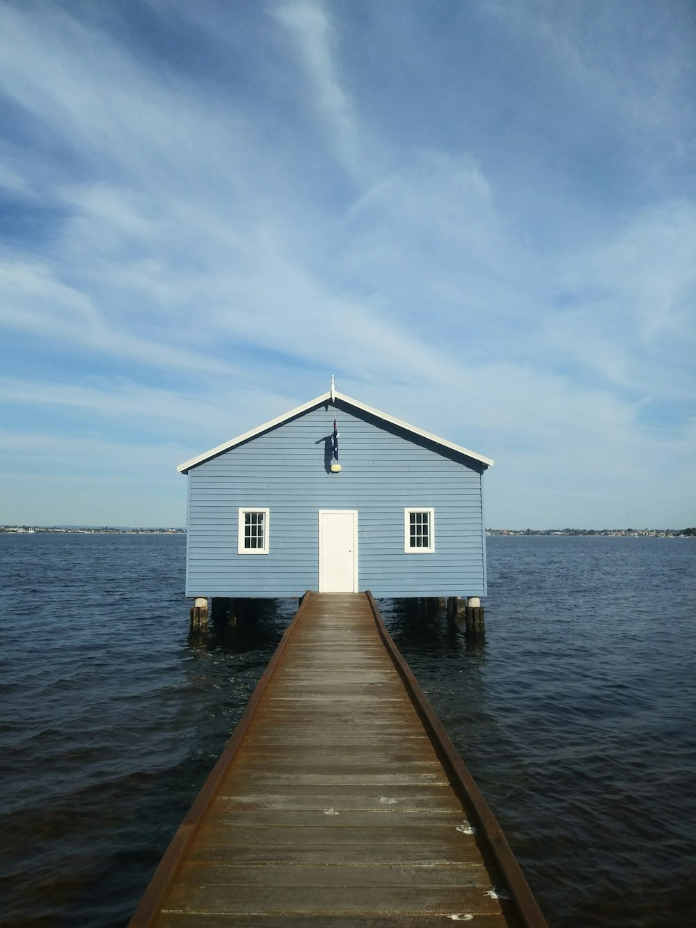 white and blue wooden house on sea under blue sky during daytime