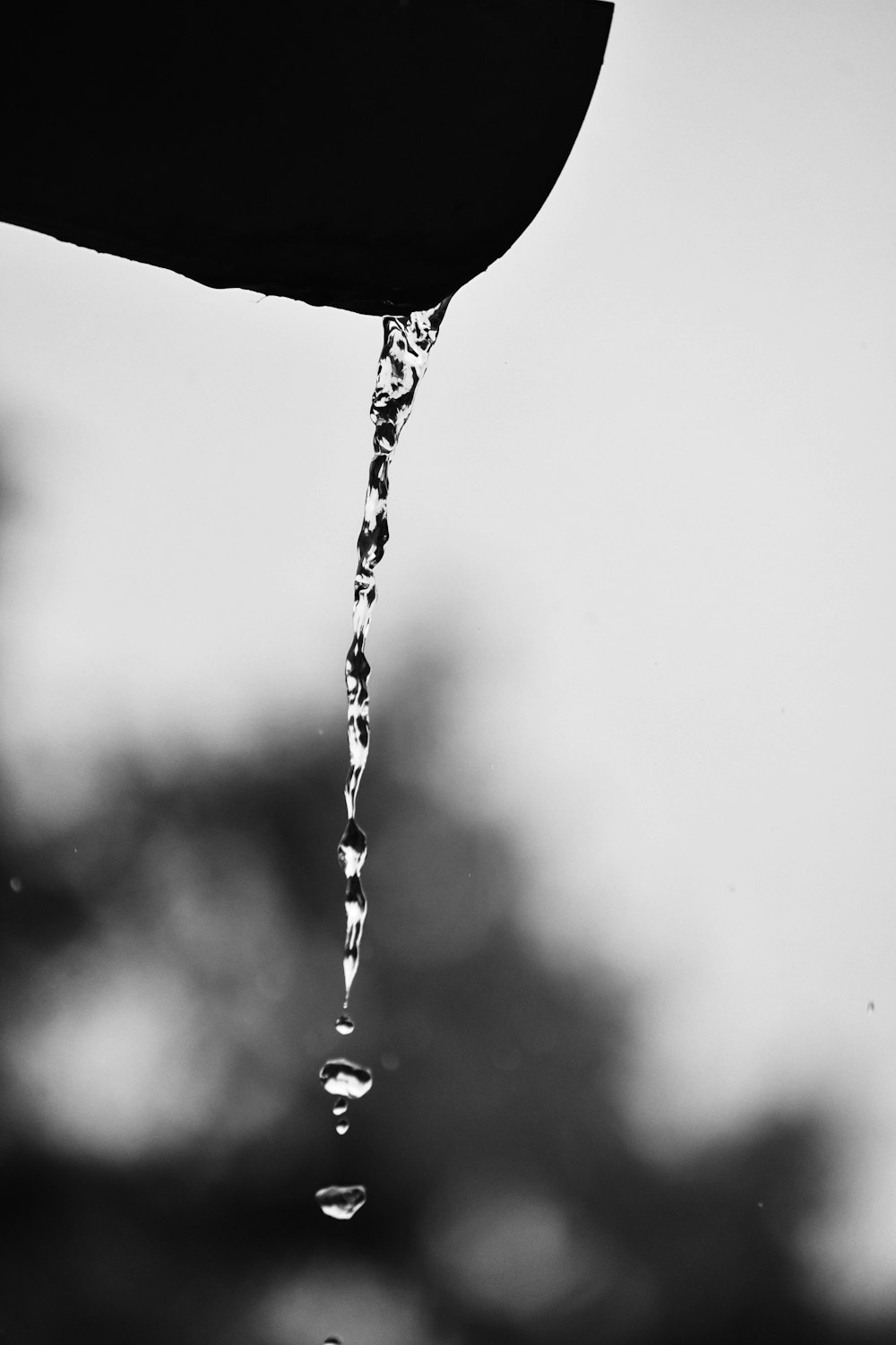 water drop on water in grayscale photography