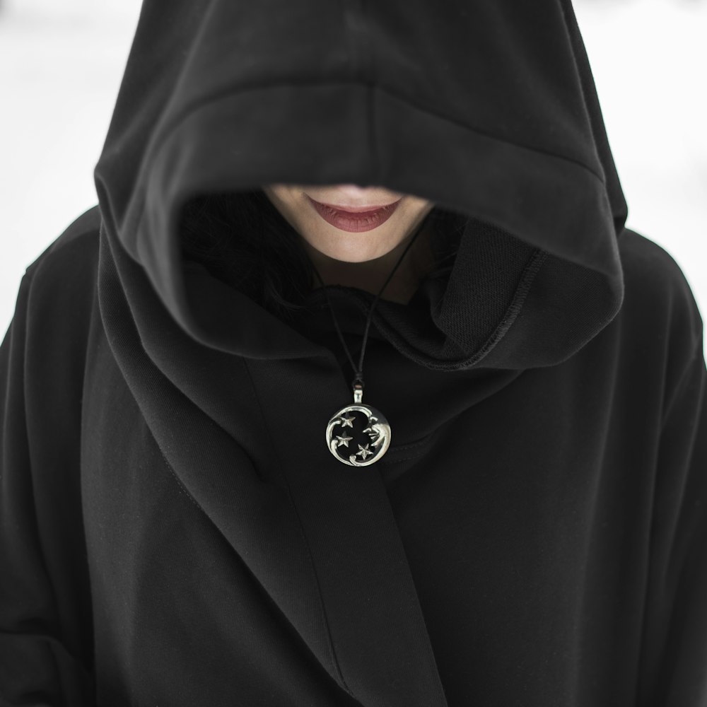 man in black hoodie standing on snow covered ground during daytime