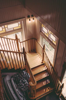 Workers carefully restoring an old wooden staircase with natural light.
