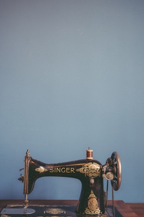 Before-and-after side by side of a classic Singer sewing machine showing wear and the fresh repaint finish.