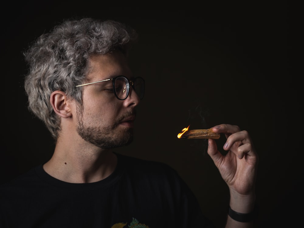 man in black crew neck shirt smoking cigarette