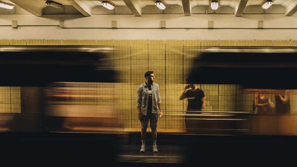 man in white jacket standing in front of train
