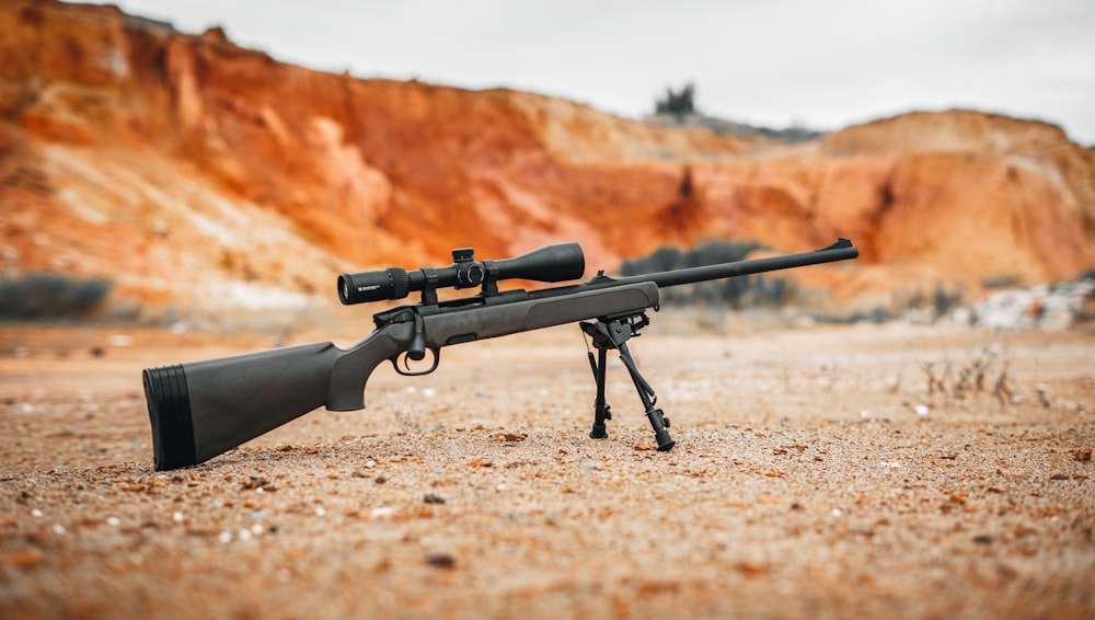 black rifle on brown dirt road during daytime