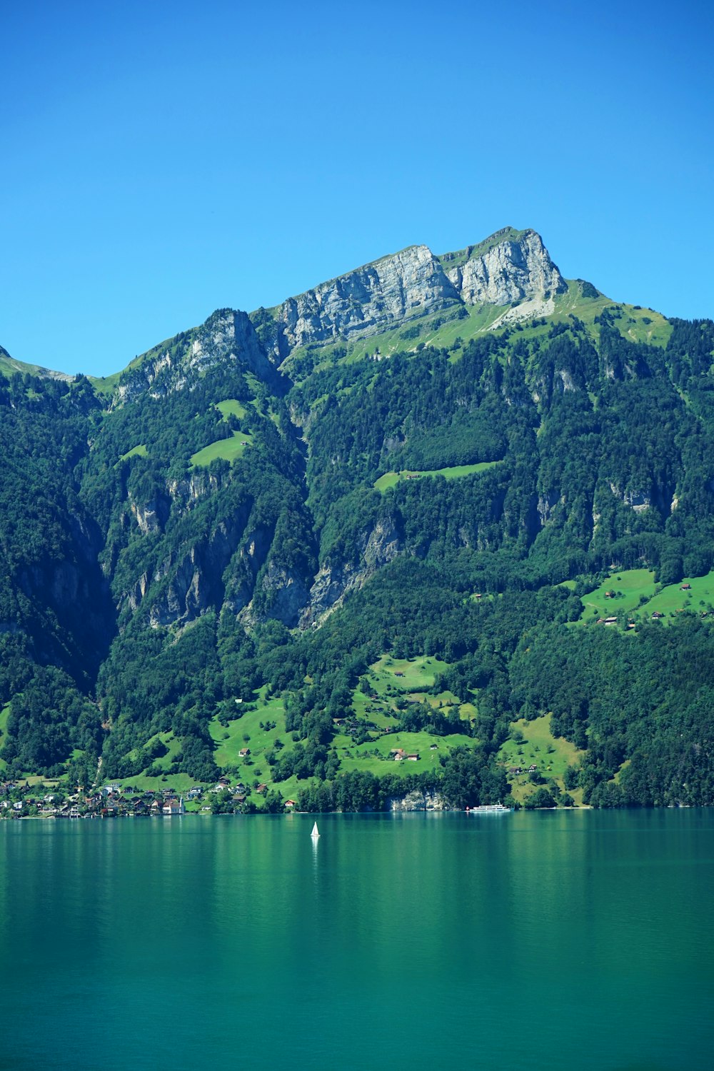 green and gray mountain beside body of water during daytime