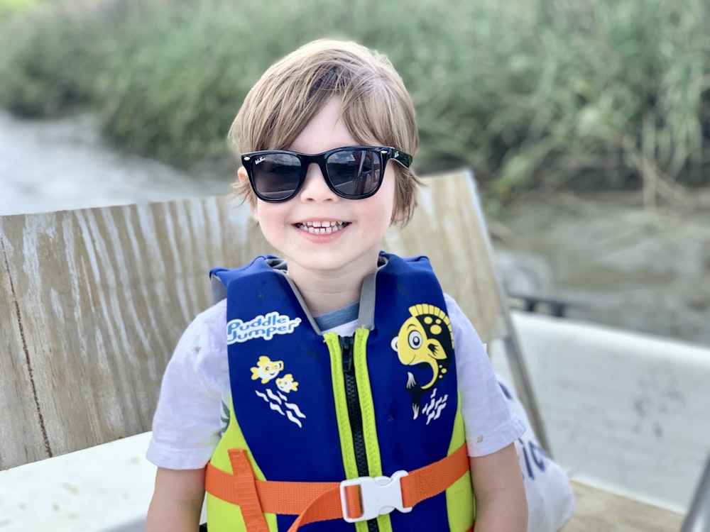 boy in blue and yellow polo shirt wearing black sunglasses