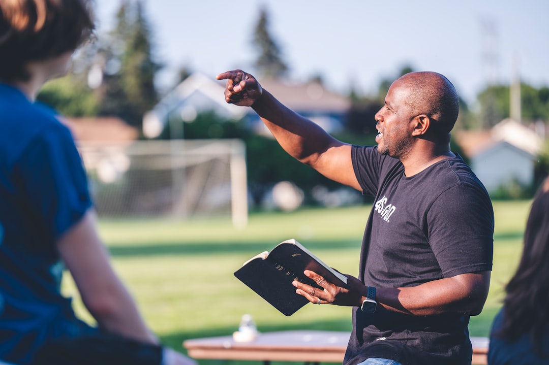 man in black crew neck t-shirt holding black tablet computer