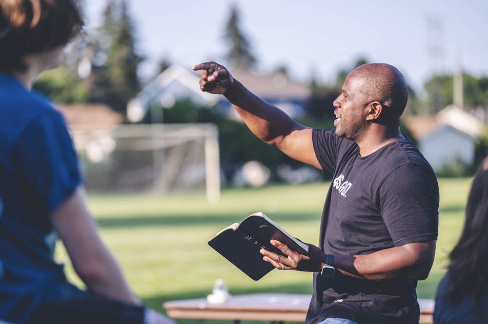 man in black crew neck t-shirt holding black tablet computer